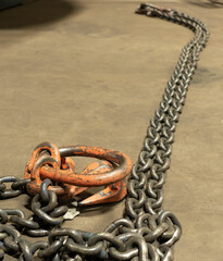 A chain for lifting heavy loads lies on the floor