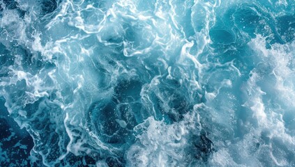 Obraz premium Aerial view of turquoise blue ocean water with waves and white foam.