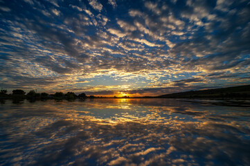 Traumhaft sch&ouml;ner Sonnenuntergang am S&uuml;&szlig;en See mit sich spiegelnden Wolken im Wasser des See