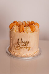 A gourmet birthday cake featuring a stylish design with delicate macarons.