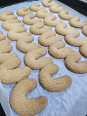 Buttery Crescent-Shaped Cookies with Powdered Sugar on Baking Sheet or in Box