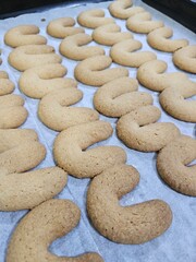 Buttery Crescent-Shaped Cookies with Powdered Sugar on Baking Sheet or in Box