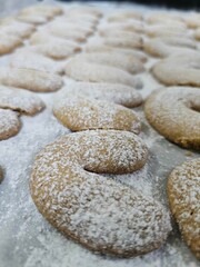 Buttery Crescent-Shaped Cookies with Powdered Sugar on Baking Sheet or in Box