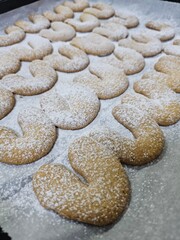 Buttery Crescent-Shaped Cookies with Powdered Sugar on Baking Sheet or in Box