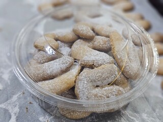 Buttery Crescent-Shaped Cookies with Powdered Sugar on Baking Sheet or in Box