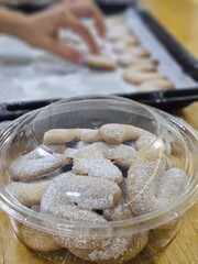 Buttery Crescent-Shaped Cookies with Powdered Sugar on Baking Sheet or in Box