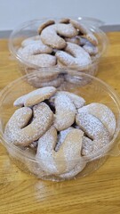 Buttery Crescent-Shaped Cookies with Powdered Sugar on Baking Sheet or in Box