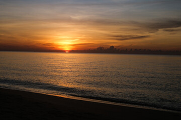 The sun rises at the sea in the morning.