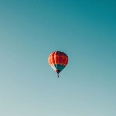 Obraz premium Colorful hot air balloon in clear blue sky, symbolizing adventure, freedom, and tranquility. Perfect for travel or outdoor themes.