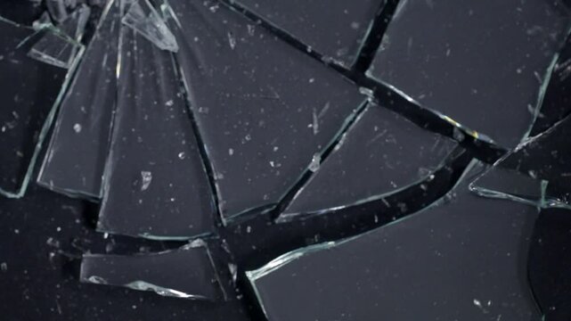 Close-up of shattered glass with intricate cracks and splinters, highlighting the fragility and damage of the material. A detailed view of broken glass creating a chaotic pattern