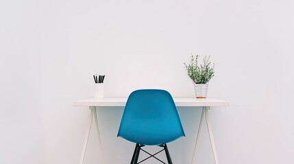 A minimalist workspace with a vibrant blue chair and a simple desk against a white wall