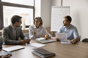 Pretty business lady explains key point related to agenda topics, marketing department sit at...
