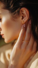 Elegant woman showcasing delicate jewelry during golden hour outdoors