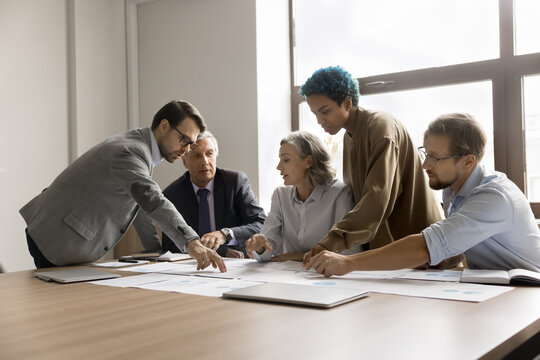 Managers, team leaders, and key stakeholders involved in strategic planning gathered in conference room, review papers with data, share opinion and vision, search solution, forecasting during briefing