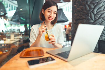 Asian woman using laptop and waiting at coffee cafe city break weekend balance lifestyle