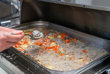 Woman puts food on her plate at the buffet. All-inclusive system.