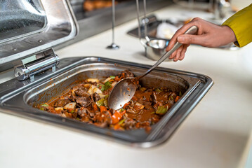 Woman puts food on her plate at the buffet. All-inclusive system.