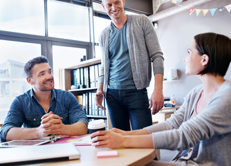 Paperwork, group and happy at desk for business, team building and discussion for project. People, collaboration and smile in office or creative agency with documents or laptop for morning and career
