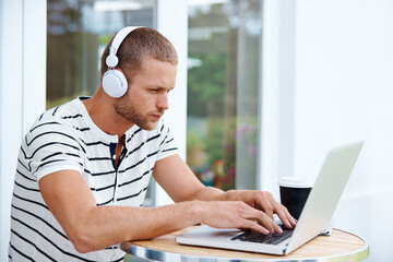 Creative, man and typing outdoor on laptop in backyard for remote work, drafting media pitch and press release. Male publicist, headphones and online for managing social accounts or planning campaign