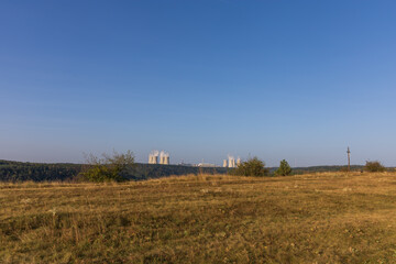 Dukovany nuclear power plant in the Czech Republic, Europe. Smoke cooling towers. There are clouds in the sky. In the foreground is the nature of the Highlands