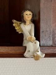 an angel sitting on a shelf