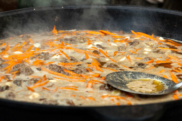 Stewed meat and carrots in a huge cauldron street food