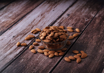 Almond in glass bowl wooden background, almond with  Bowl on a wooden table, vintage old effect texture background