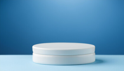 White ceramic podium. Scene for product presentation on blue backdrop.
