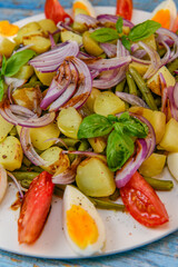 Fresh salad, green beans, small potatoes, egg, tomato, basil, red onions and balsamic vinaigrette. High quality photo