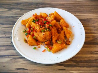 a plate of crispy Tahu Cabe Garam (chili salt tofu) snacks. Spicy fried tofu sprinkled with dried red and green chilies