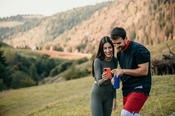Fototapeta premium Happy man and beautiful woman smiling while resting after running. Woman and man taking a break after fitness.