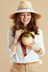 smiling stylish woman in blouse and shorts on beige