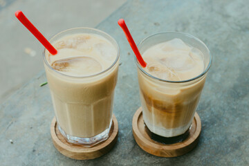 This drink is called palm sugar milk coffee, served with ice cubes in a glass. Photo taken from the top corner