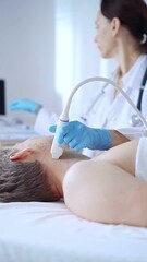 Obraz premium Doctor woman wearing blue medical gloves performing neck ultrasound exam on male patient. Medicine service concept
