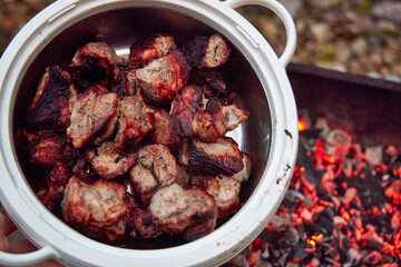 a pan of pork kebabs on the coals