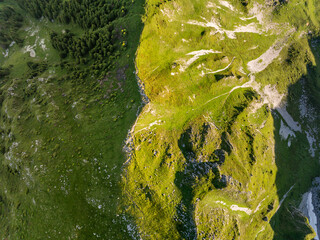 Aerial view of mountains with grass and rocks in Switzerland. Hiking in tranquil nature. Background with alpine pattern.