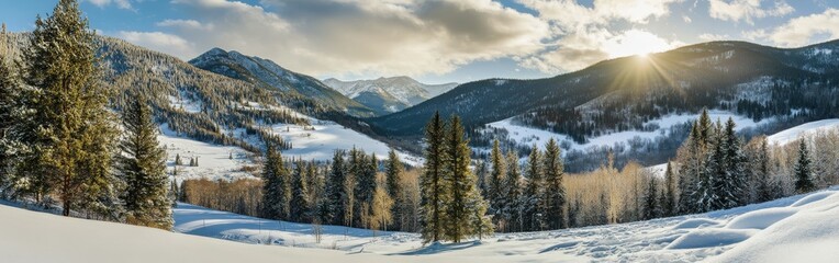 Winter landscape with snow-covered mountains and sun in the distance
