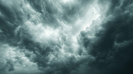 Fototapeta premium Turbolent gray clouds with a glimmer of light. Sky replacement.