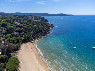 Aerial view on boats, crystal clear blue water of Plage du Debarquement white sandy beach near Cavalaire-sur-Mer and La Croix-Valmer, summer vacation on French Riviera, Var, France