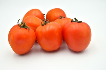 Hand holding fresh and red tomato