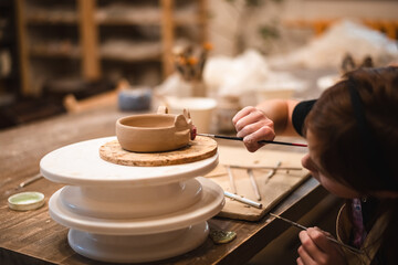girl hands, pottery studio and painting cup in workshop for sculpture