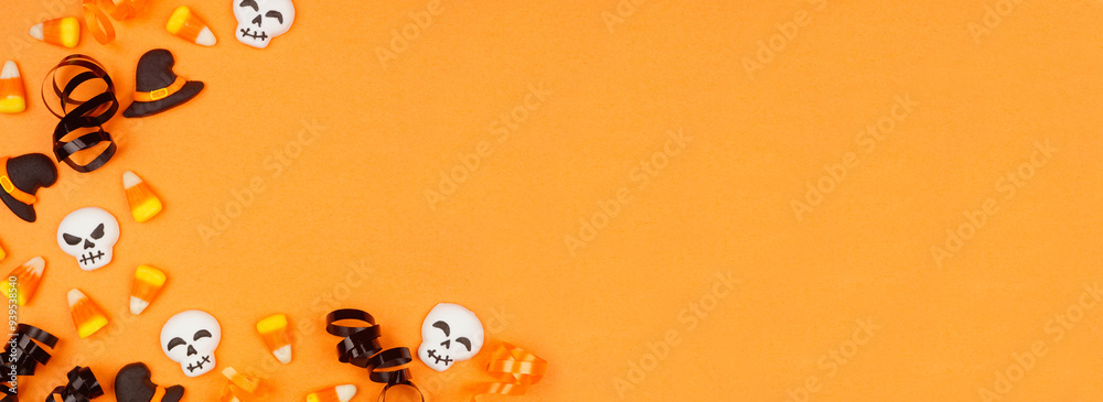 Poster halloween corner border of black, white and orange color candy and ribbon. top view on an orange ban
