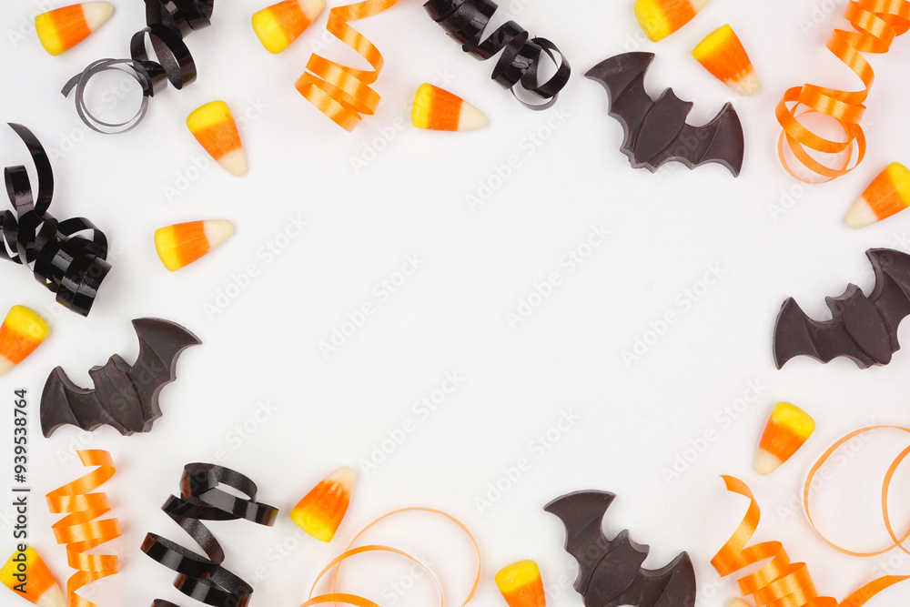 Poster halloween frame of black, white and orange color candy and ribbon. overhead view on a white backgrou