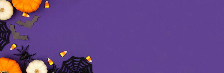 Halloween corner border of pumpkins, candy and spooky decor. Overhead view on a purple banner background with copy space.