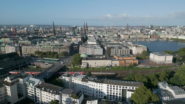 Aerial panorama view of the Hamburg skyline, Germany. The city is seen from above with dense urban development, modern and historic buildings, and wide streets stretching toward the horizon. This pano