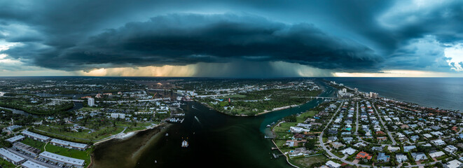 Aerial Panoramic view of Heavy clouds of a storm front over the Loxahatchee River and the city of Jupiter in early August. Rain is visible, which pours out of the clouds on the city