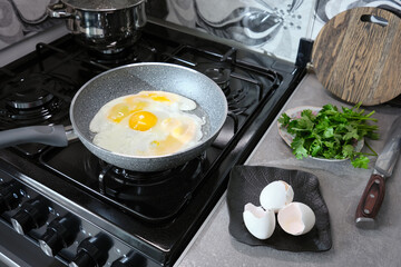 A non-stick frying pan cooks an omelet on a gas stove.