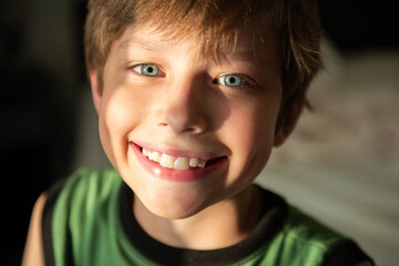 Cinematic close-up of a child's blue eyes. Home comfort. Portrait of a happy kid on a summer sunny day