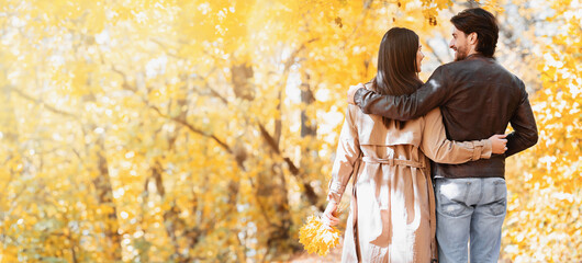 Unrecognizable lovers spending weekend together in autumn forest, free space