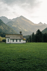 View of a small white church in Stillachtal in Germany. In the background, the Trettachspitze and Mädelegabel mountains near Birgsau.